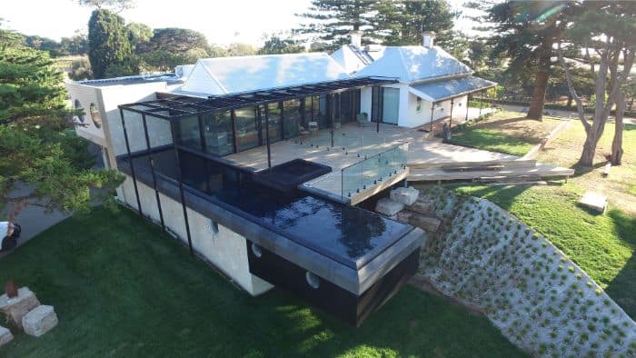 Folding Arm Awnings & Markilux Awnings Stockist - a view from above of a house with an awning and deck with swimming pool