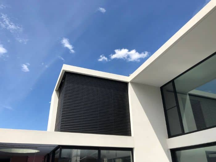 Order External Venetian Blinds - the outside view of a window with dark venetian blinds dropped covering the window