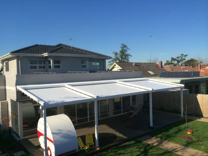 Folding Arm Awnings & Markilux Awnings Stockist - a view of a house with an closed awning and wooden deck