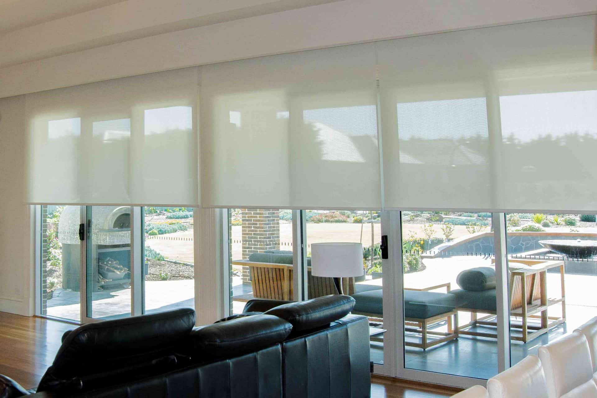 Light filtering motorised roller blinds in living room by SOM Blinds