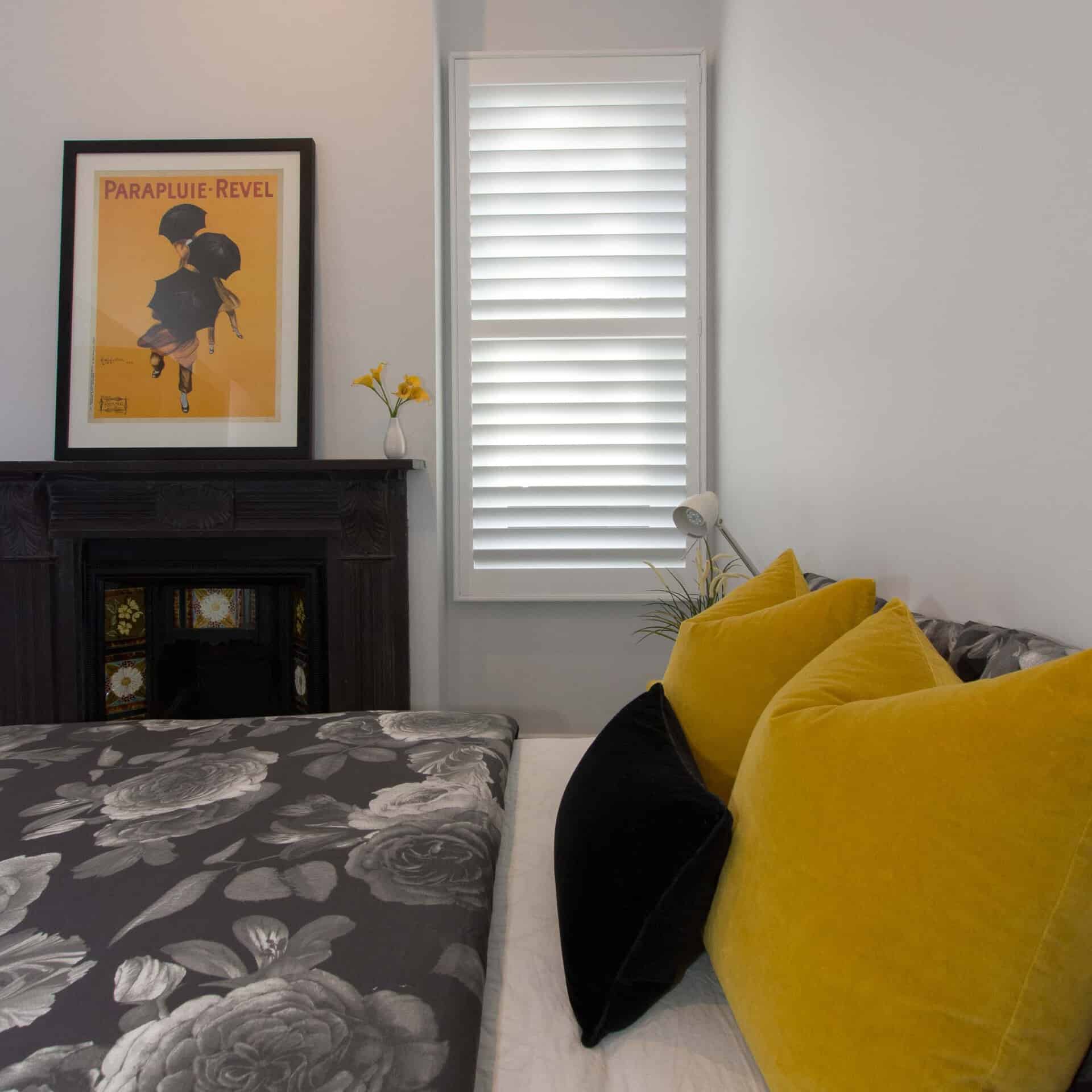 Plantation Shutters In Timber Or Aluminium - a bedroom with a bed and white window covered by shutter blinds and a picture on the wall