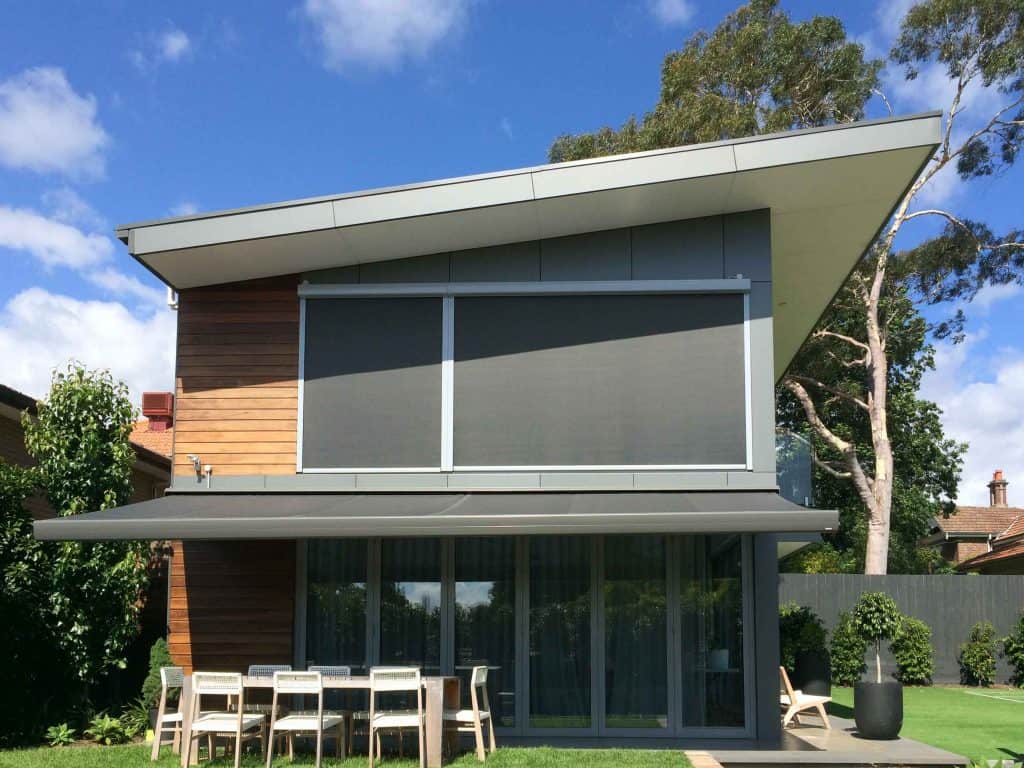 Folding Arm Awnings & Markilux Awnings Stockist - a double story house with an awning and blinds covering the windows