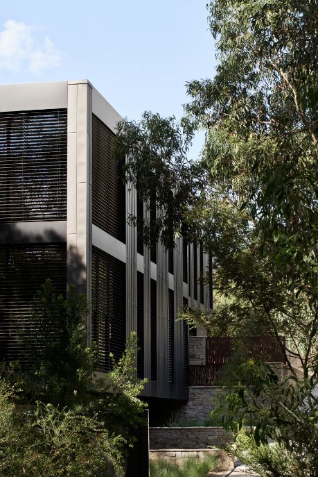 External Venetian Blinds - a side image of a large square home covered in Venetian blinds in a dark black colour