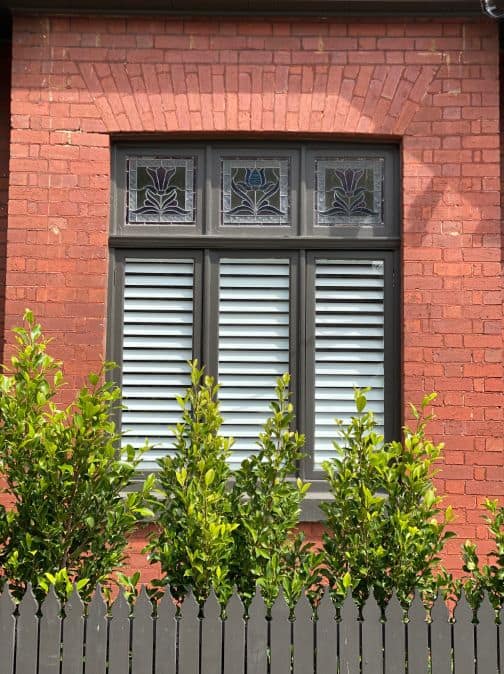 Plantation Shutters - Three window panes, with plantation shutters on the inside, old school glass pane designs on the window