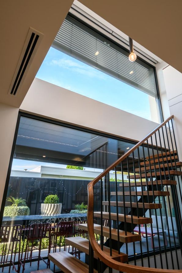 External Venetian Blinds - a wooden staircase with a large window at the top of the stairwell