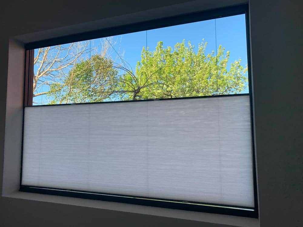 Honeycomb blinds giving privacy to the bottom area of a window