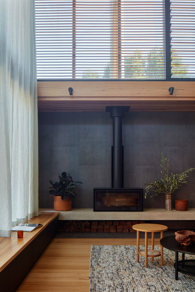 Timber living space with open fire and sheer curtains and external venetians
