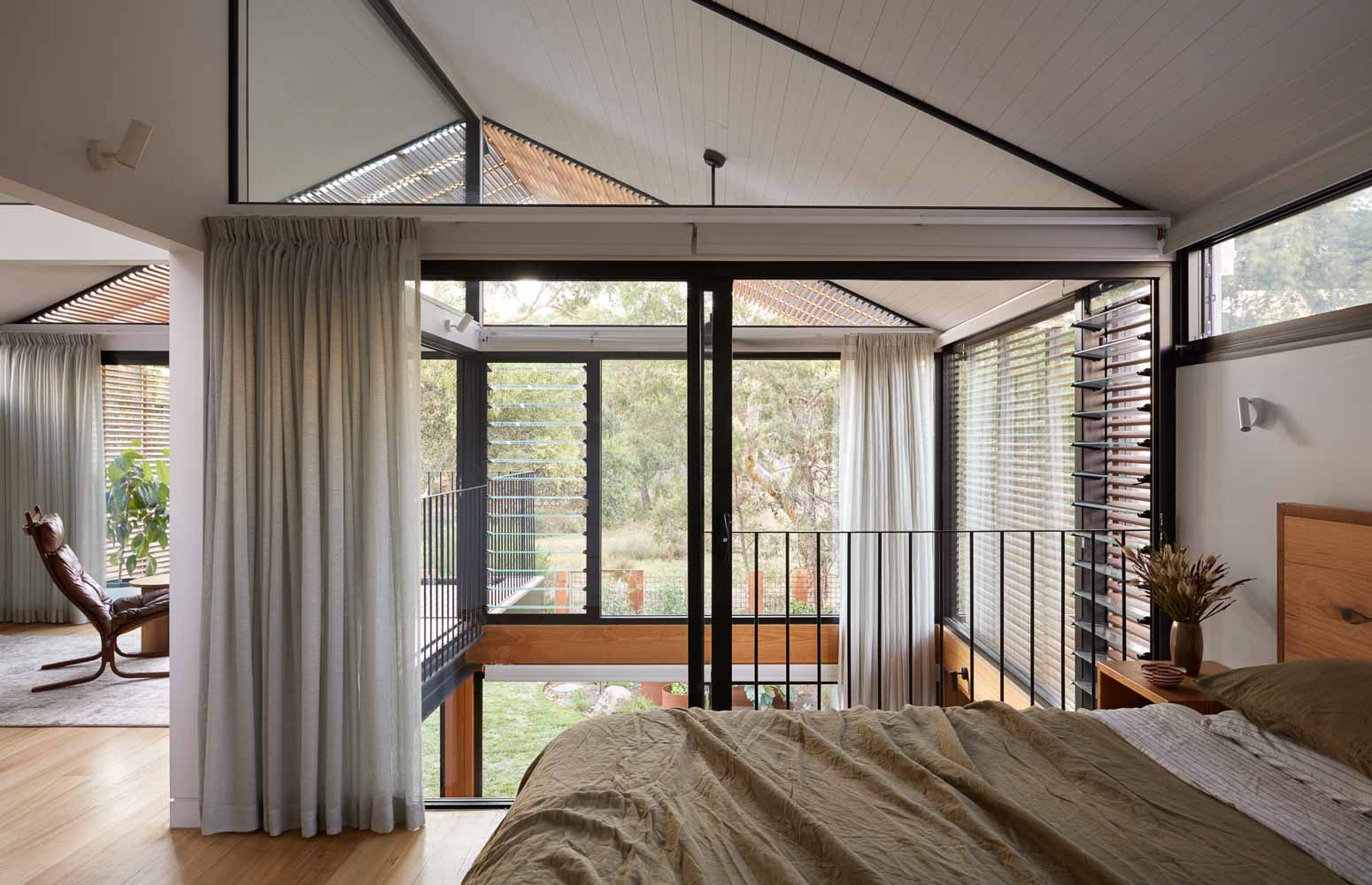 Restful bedroom with sheer curtain looking out into trees
