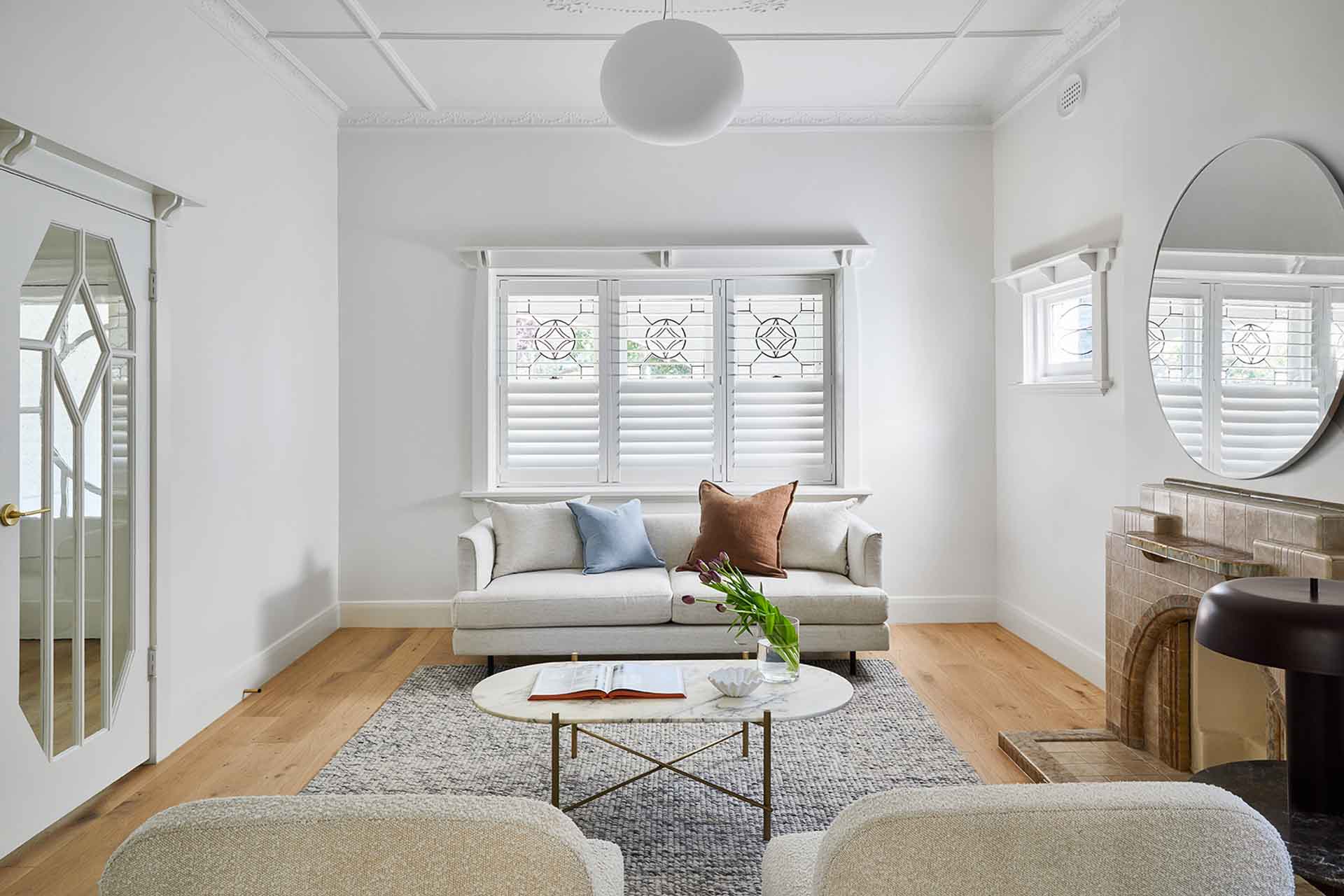 Plantation shutters in siting room on tradtional timber window