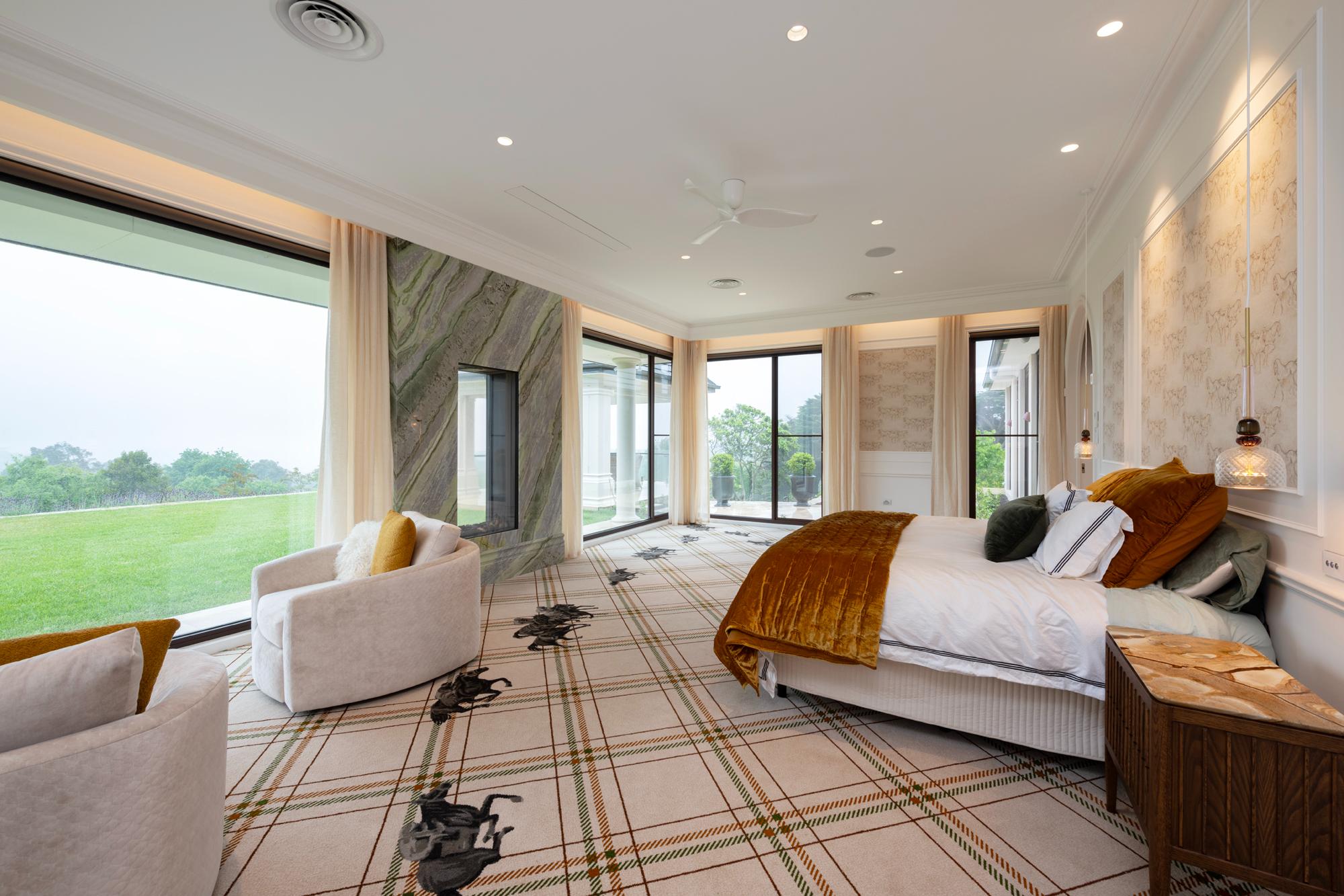 Large bedroom expansive windows with open motorised sheer curtains in recessed custom pelmets, carpet features racehorses racing across the room