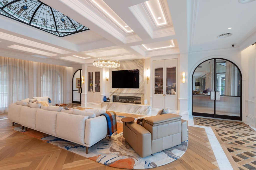 Elegant living room with sheer curtains and marble fireplace, built in joinery and inset timber flooring with marble edges