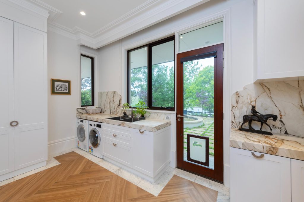 Modern marble laundry with honeycomb blind on glazed timber door