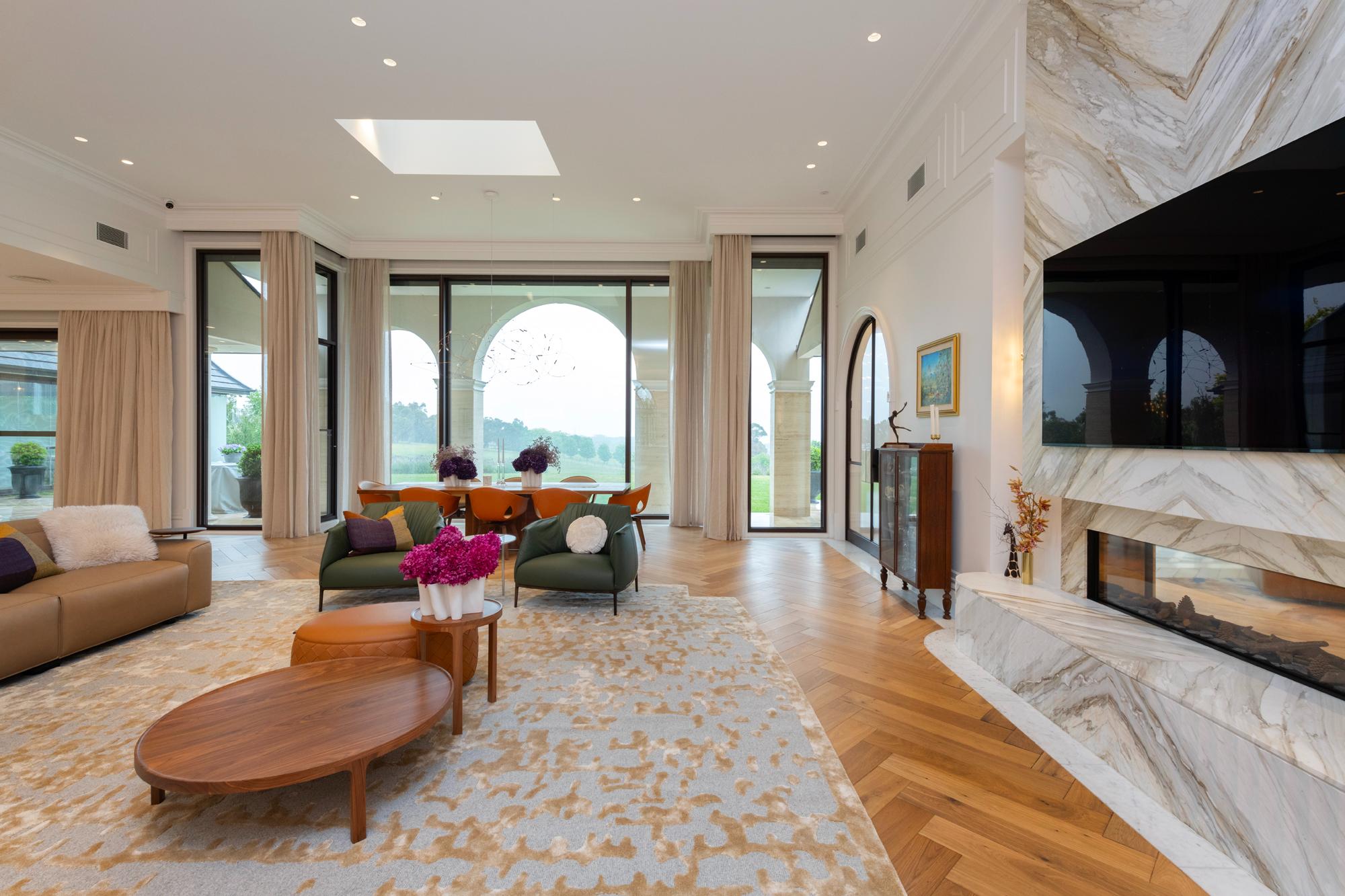 Dining and living rooms with floor to ceiling sheer curtains and modern leather furniture