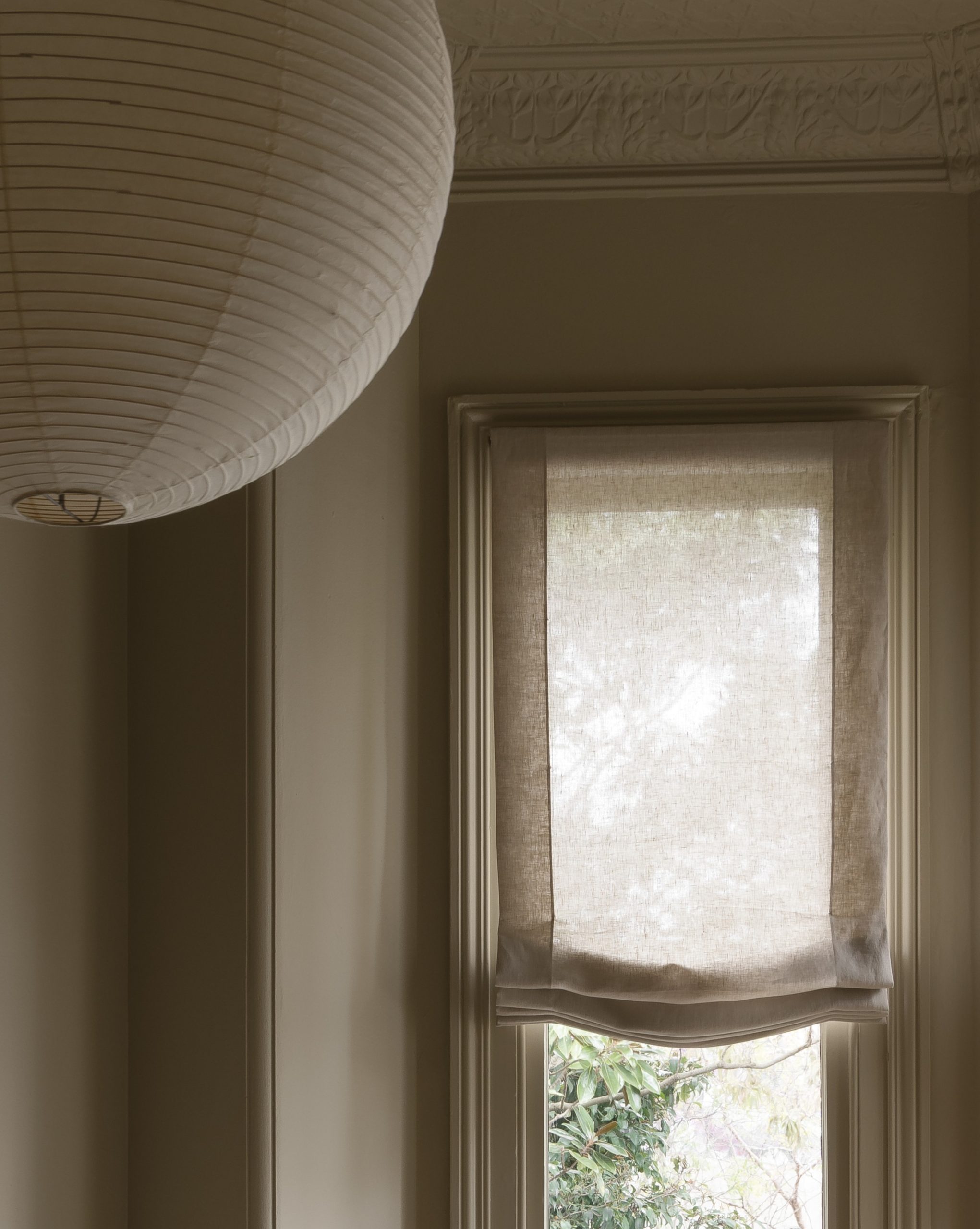 Close up of double hung window with unlined soft motorised roman blind raised halfway at WD Residence Toorak by Selzer Design Studio